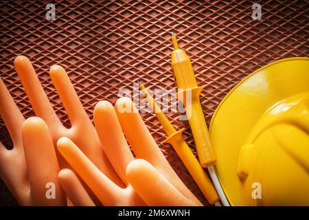 Schutzhelm-Isolierhandschuhe Elektrischer Tester auf dielektrischer Abdeckung. Stockfoto