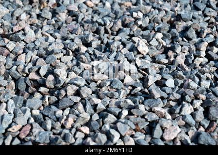 Granitkies-Textur. Nahaufnahme Kies-Textur. Grauer Kies-Hintergrund, graue Textur neben dem Haus, Nahaufnahme von oben. Stockfoto