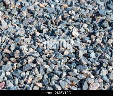 Granitkies-Textur. Nahaufnahme Kies-Textur. Grauer Kies-Hintergrund, graue Textur neben dem Haus, Nahaufnahme von oben. Stockfoto
