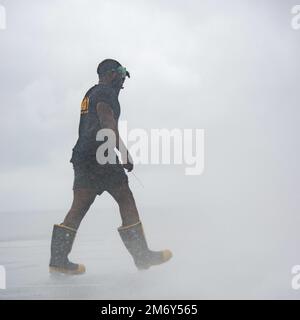 220510-N-DW158-1065 PACIFIC OCEAN (10. Mai 2022) Damage Controlman 3. Klasse Antonio Polk aus Moss Point, Mississippi, bereitet sich auf die Inspektion eines abwaschbaren Regners im Cockpit der USA vor Der einzige nach vorn eingesetzte Flugzeugträger der Navy USS Ronald Reagan (CVN 76), der während eines Tests des Abwaschsystems für Gegenmaßnahmen am Schiff eingesetzt wurde. Das Abwaschsystem für Gegenmaßnahmen wird vor, während und nach einer chemischen Kontamination verwendet, um schädliche Chemikalien oder Agenzien an der Außenseite des Schiffes zu entfernen. Ronald Reagan, das Flaggschiff der Carrier Strike Group 5, stellt eine kampfbereite Truppe bereit Stockfoto