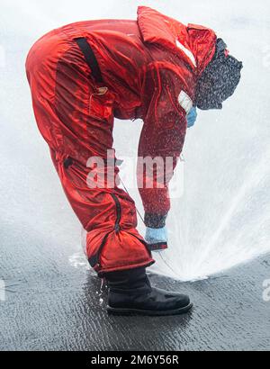 220510-N-DW158-1039 PACIFIC OCEAN (10. Mai 2022) Aviation Boatswain’s Mate (Handling) Airman Jalen Simmons aus Tallahassee, Florida, inspiziert einen abwaschbaren Sprinkler im Cockpit der USA Der einzige nach vorn eingesetzte Flugzeugträger der Navy USS Ronald Reagan (CVN 76), der während eines Tests des Abwaschsystems für Gegenmaßnahmen am Schiff eingesetzt wurde. Das Abwaschsystem für Gegenmaßnahmen wird vor, während und nach einer chemischen Kontamination verwendet, um schädliche Chemikalien oder Agenzien an der Außenseite des Schiffes zu entfernen. Ronald Reagan, das Flaggschiff der Carrier Strike Group 5, ist kampfbereit Stockfoto