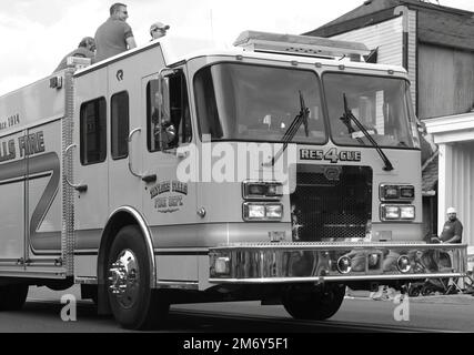 Taylors Falls Feuerwehr-Rettungswagen mit Feuerwehrleuten bei der Wannigan Days Parade an einem Sommertag in St. Croix Falls, Wisconsin, USA. Stockfoto