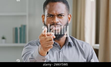 Wütender, aggressiver, bärtiger afroamerikanischer Geschäftsmann professioneller HR-Manager, Arbeitgeber, Büroangestellter, der mit dem Finger auf die Bedrohung durch die Kamera zeigt Stockfoto