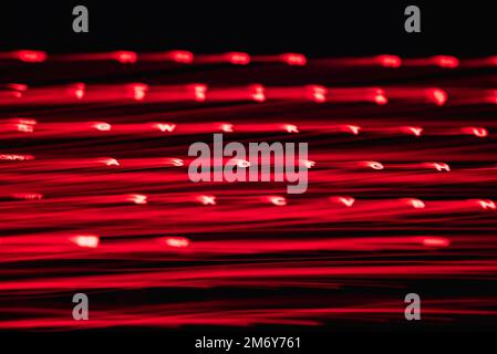 Leicht gemalte Buchstaben und Zahlen auf der Tastatur. Wunderschöner, farbenfroher Hintergrund. Lichtermalerei mit langer Belichtung, rote gekrümmte Linien in leuchtendem Neon. Stockfoto