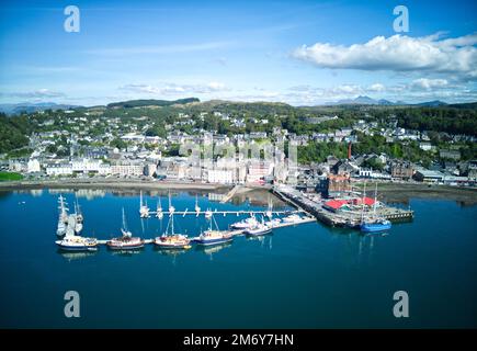 Drohnenansicht von Oban Bay aus der Vogelperspektive. Mit Blick auf Oban Pontons, Stadtzentrum, North Pier und Oban Esplanade, McCaigs Tower und Ben Cruachan Stockfoto