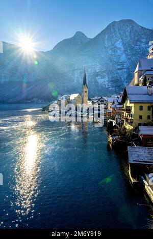 Wunderschöne sonnige Stadtlandschaft der besonderen Stadt Hallstatt in Österreich Salzkammergut verschneite Winterberge, See und Kirche Stockfoto