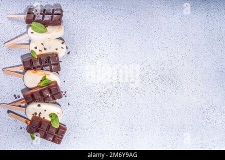 Schokolade- und Vanillepopsicles, klassischer dunkelbrauner Kakao und Milcheis-Lolly-Pops. Stapel von verschiedenen Eis-Lollies flach Draufsicht CO Stockfoto