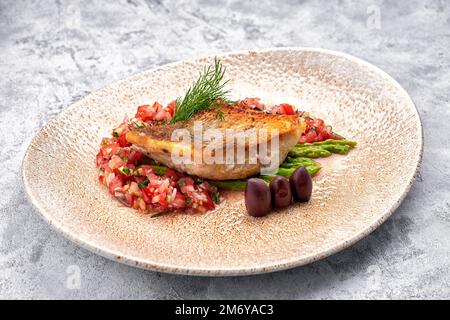 Ein Stück gebratener Zander-Fisch mit Gemüse auf einem Teller Stockfoto