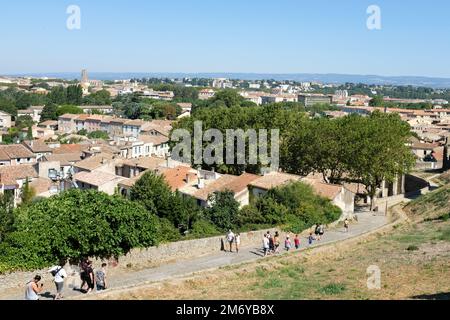 Carcassonne, Frankreich - Touristen gehen von der alten, auf einem Hügel gelegenen Festung hinunter ins Zentrum von Carcassonne. 2022. Stockfoto