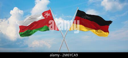 Zwei überkreuzte Flaggen Bundesrepublik Deutschland und Oman winken im Wind am bewölkten Himmel. Beziehungskonzept, Dialog, Reisen zwischen zwei Ländern Stockfoto