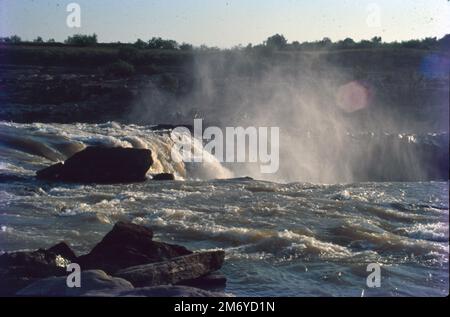 Die Dhuandhar-Fälle (धुआंधार) sind ein Wasserfall im Bezirk Jabalpur im indischen Bundesstaat Madhya Pradesh. Dhuandhar-Wasserfälle in Bhedaghat. Der Fluss Narmada, der sich durch die weltberühmten Marmorfelsen zieht, verengt sich und stürzt dann in einen Wasserfall, der als Dhuandhar bekannt ist. Stockfoto