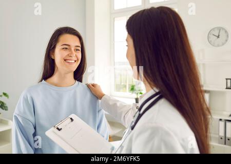 Weiße Frau lächelt, Freude empfindet von der Unterstützung des Arztkrankenhauses, die Hand auf Schulter legte Stockfoto