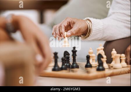 Menschen, die im Haus Hand oder Schachritter spielen, zu Hause oder auf einem Wohnzimmertisch im Strategieplatzspiel, Schachmatt-Vision oder Wettbewerb. Zoom, Frauen oder Stockfoto