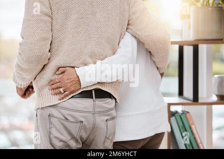 Liebe, Umarmung und Seniorenpaar zu Hause, stehend, verbunden und verbringen schöne Zeit miteinander. Pflege, Unterstützung und ältere Frau im Ruhestand Stockfoto