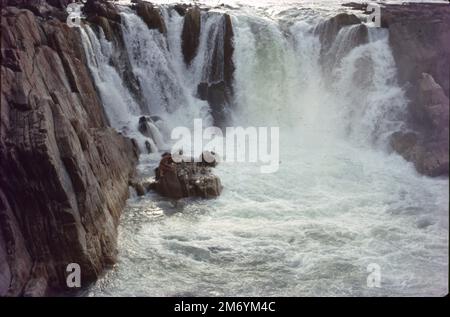 Die Dhuandhar-Fälle (धुआंधार) sind ein Wasserfall im Bezirk Jabalpur im indischen Bundesstaat Madhya Pradesh. Dhuandhar-Wasserfälle in Bhedaghat. Der Fluss Narmada, der sich durch die weltberühmten Marmorfelsen zieht, verengt sich und stürzt dann in einen Wasserfall, der als Dhuandhar bekannt ist. Stockfoto