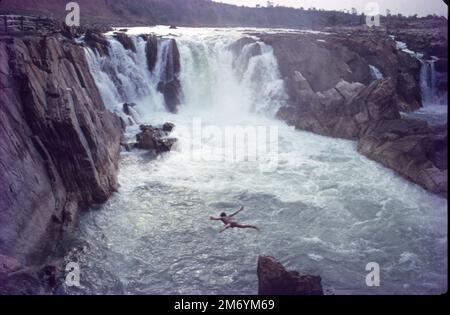 Die Dhuandhar-Fälle (धुआंधार) sind ein Wasserfall im Bezirk Jabalpur im indischen Bundesstaat Madhya Pradesh. Dhuandhar-Wasserfälle in Bhedaghat. Der Fluss Narmada, der sich durch die weltberühmten Marmorfelsen zieht, verengt sich und stürzt dann in einen Wasserfall, der als Dhuandhar bekannt ist. Stockfoto