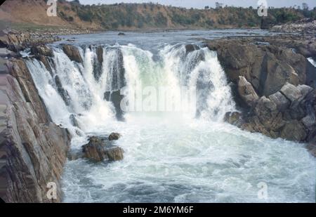 Die Dhuandhar-Fälle (धुआंधार) sind ein Wasserfall im Bezirk Jabalpur im indischen Bundesstaat Madhya Pradesh. Dhuandhar-Wasserfälle in Bhedaghat. Der Fluss Narmada, der sich durch die weltberühmten Marmorfelsen zieht, verengt sich und stürzt dann in einen Wasserfall, der als Dhuandhar bekannt ist. Stockfoto