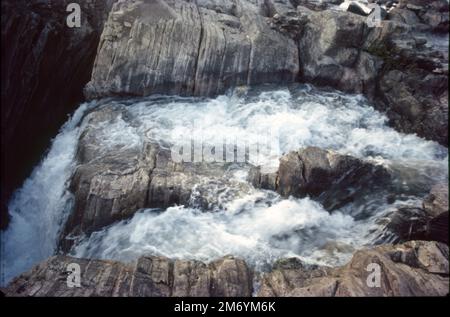 Die Dhuandhar-Fälle (धुआंधार) sind ein Wasserfall im Bezirk Jabalpur im indischen Bundesstaat Madhya Pradesh. Dhuandhar-Wasserfälle in Bhedaghat. Der Fluss Narmada, der sich durch die weltberühmten Marmorfelsen zieht, verengt sich und stürzt dann in einen Wasserfall, der als Dhuandhar bekannt ist. Stockfoto