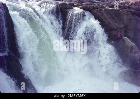 Die Dhuandhar-Fälle (धुआंधार) sind ein Wasserfall im Bezirk Jabalpur im indischen Bundesstaat Madhya Pradesh. Dhuandhar-Wasserfälle in Bhedaghat. Der Fluss Narmada, der sich durch die weltberühmten Marmorfelsen zieht, verengt sich und stürzt dann in einen Wasserfall, der als Dhuandhar bekannt ist. Stockfoto