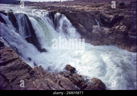 Die Dhuandhar-Fälle (धुआंधार) sind ein Wasserfall im Bezirk Jabalpur im indischen Bundesstaat Madhya Pradesh. Dhuandhar-Wasserfälle in Bhedaghat. Der Fluss Narmada, der sich durch die weltberühmten Marmorfelsen zieht, verengt sich und stürzt dann in einen Wasserfall, der als Dhuandhar bekannt ist. Stockfoto