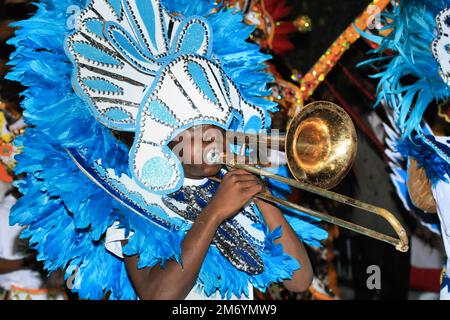 Ein Mann spielt Posaune in einem traditionellen Kostüm während einer Junkanoo-Parade auf den Bahamas. Stockfoto