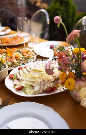 Hochzeit. Bankett. Stühle und ein Tisch für Gäste, dekoriert mit Kerzen, werden mit Besteck und Geschirr serviert und mit gelber Tischdecke bedeckt. Die Stockfoto