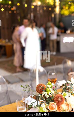 Hochzeit. Bankett. Stühle und ein Tisch für Gäste, dekoriert mit Kerzen, werden mit Besteck und Geschirr serviert und mit gelber Tischdecke bedeckt. Die Stockfoto