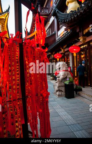 Shanghai, China – 01032023: Auf roten Papierstreifen, die zum chinesischen Neujahr im Yuyuan von Shanghai an einen Baum gebunden sind, werden Glückwünsche geschrieben. Stockfoto