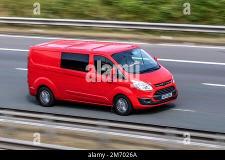 Red Ford Transit Panel Van 2013. 2198cc Diesel 6-Gang-Minibus mit Schaltfenster, Fahrt auf der Autobahn M6, Manchester, Großbritannien Stockfoto