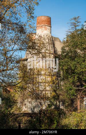 Castelveccana, Italien- 12-27-2022: Rote Ziegelschornsteine und verlassene Öfen mit Vegetation bedeckt in Caldè am Lago Maggiore Stockfoto