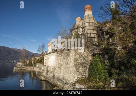 Castelveccana, Italien- 12-27-2022: Rote Ziegelschornsteine und verlassene Öfen mit Vegetation bedeckt in Caldè am Lago Maggiore Stockfoto