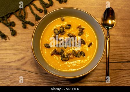 Kürbisseife mit Köpfen auf einem Teller auf einem Holztisch Stockfoto