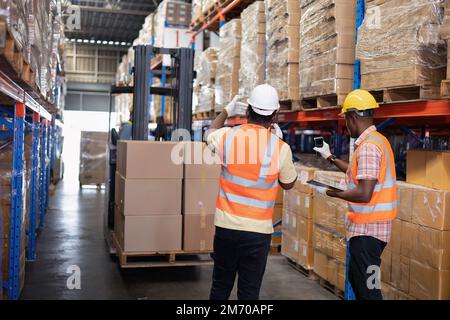 Mitarbeiter im Lagerlager verwenden den Tablet-pc zum Prüfen, Scannen des Barcodes und Lagern im Regal Stockfoto