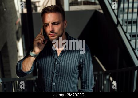 Ein Typ in Hemd und Hose posiert und läuft durch die Stadt Stockfoto