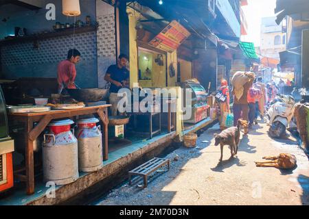 Pushkar, Indien - 7. November 2019: Indische Straße mit Menschen und Imbissstand mit indischem Koch macht frisches Street Food Murukku Stockfoto