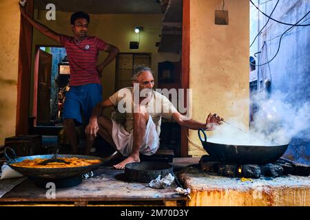 Pushkar, Indien - 7. November 2019: Street Food Stand Kochen mit Löffel süßes puri-Brot und Rabri-süßes Gericht auf Kondensmilch-Basis in str Stockfoto