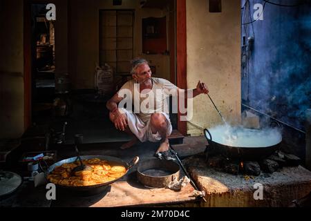 Pushkar, Indien - 7. November 2019: Street Food Stand Kochen mit Löffel süßes puri-Brot und Rabri-süßes Gericht auf Kondensmilch-Basis in str Stockfoto