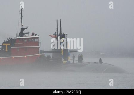 Groton, Usa. 03. Januar 2023. Die USA Das Navy Virginia-Klasse-Schnellangriff-U-Boot USS Newport News wird von einem Schlepper unterstützt, das die Themse hinunterfährt, um auf der Naval Submarine Base New London, 3. Januar 2023 in Groton, Connecticut, zu Homecoming zu kommen. Newport News kehrte nach einem sechsmonatigen Einsatz zum Homeport zurück. Kredit: John Narewski/USA Navy/Alamy Live News Stockfoto