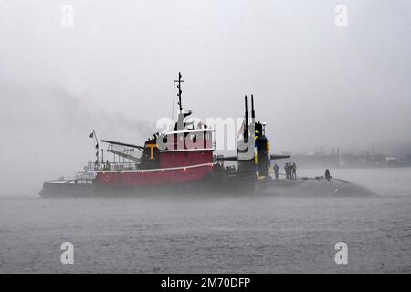 Groton, Usa. 03. Januar 2023. Die USA Das Navy Virginia-Klasse-Schnellangriff-U-Boot USS Newport News wird von einem Schlepper unterstützt, das die Themse hinunterfährt, um auf der Naval Submarine Base New London, 3. Januar 2023 in Groton, Connecticut, zu Homecoming zu kommen. Newport News kehrte nach einem sechsmonatigen Einsatz zum Homeport zurück. Kredit: MCS Joshua Karsten/USA Navy/Alamy Live News Stockfoto