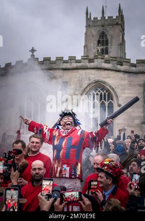 Der zeremonielle Narr, James Chatwin, hält eine Rede während des Rauchens des Narr, während er den Haxey Hood beginnt, eine alte Tradition aus dem 14. Jahrhundert im Dorf Haxey in North Lincolnshire. Teams, die Pubs aus zwei lokalen Dörfern, Haxey und Westwoodside, vertreten, kämpfen um die Kapuze - ein Lederschlauch - für ihren Pub-Vermieter. Die Haube wird in die Menge geworfen und nach vorn in Richtung der Pubs geschwenkt, die als Tore bekannt sind, ohne dass sie getreten oder geworfen wird. Der preisgekrönte Pub zeigt die Kapuze bis zum nächsten Jahr. Foto: Freitag, 6. Januar 2023. Das Spiel geht zurück Stockfoto