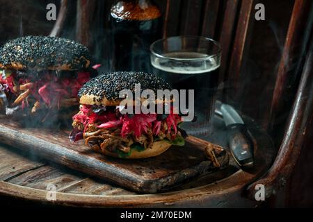 Burger mit Schweinefleisch und schwarzem Sesam mit knusprigem Apfelsalat, eingelegtem Rotkohl, knusprigem Apfelsalat, amerikanischer Flagge, Unabhängigkeitstag der USA Stockfoto