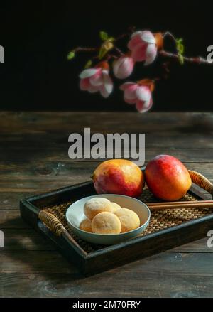 japanische Mango-Mochi-Kuchen mit Eiscreme auf einem klassischen asiatischen Holztablett Stockfoto