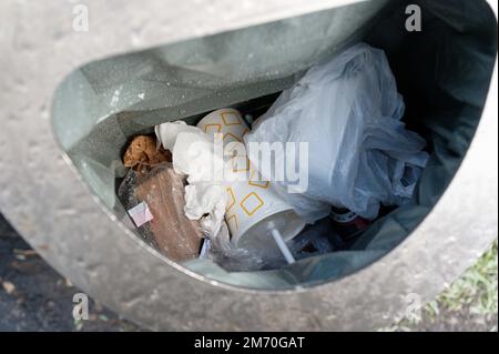 Köln, Deutschland. 06. Januar 2023. Einwegbecher liegen in einem Müllcontainer in der Nähe mehrerer Fast-Food-Restaurants. Kunden in Deutschland haben seit Januar 1 das Recht, Getränke und Mahlzeiten zum Mitnehmen in wiederverwendbaren Verpackungen zu erhalten. Einwegverpackungen bleiben im Umlauf. Kredit: Henning Kaiser/dpa/Alamy Live News Stockfoto