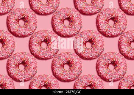 Donuts mit Streuseln auf pinkfarbenem Hintergrund. Nahtloses Muster. Helles Zuckerkonzept in Draufsicht. Süßes Junkfood. Stockfoto