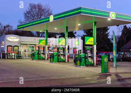 Der Vorplatz der BP-Tankstelle in der Abenddämmerung mit einem Marks and Spencer Simply Food Outlet Shop in Shepperton High Street Surrey England Stockfoto