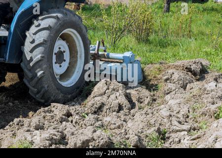 Beim Fräsen des Traktors lockert sich der Boden und wird zur Vorbereitung des Pflanzens geschliffen. Stockfoto