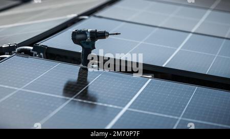 Schraubendreher zur Befestigung von Solarpaneelen an einem Firmendach Stockfoto