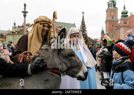 Warschau, Polen. 06. Januar 2023. Ein kleiner Junge (R) reagiert auf den Esel, während er neben den Personen steht, die während der Prozession die Kostüme tragen. Epiphany (Trzech Króli oder Three Kings) wird in Polen mit riesigen Paraden an den 12. Weihnachtsabenden gefeiert. Dieses Jahr wurde gefeiert, um die in Polen lebenden Ukrainer zu unterstützen. In Warschau beginnt er in der Nähe des Schlossplatzes und endet am Pilsudzki-Platz. Kredit: SOPA Images Limited/Alamy Live News Stockfoto