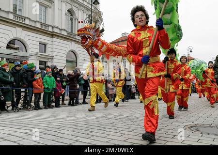 Warschau, Polen. 06. Januar 2023. Junge Männer tragen während der Prozession Drachenfiguren. Epiphany (Trzech Króli oder Three Kings) wird in Polen mit riesigen Paraden an den 12. Weihnachtsabenden gefeiert. Dieses Jahr wurde gefeiert, um die in Polen lebenden Ukrainer zu unterstützen. In Warschau beginnt er in der Nähe des Schlossplatzes und endet am Pilsudzki-Platz. Kredit: SOPA Images Limited/Alamy Live News Stockfoto