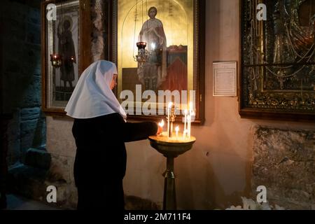 Eine östlich-orthodoxe Nonne zündet Kerzen in der russischen Kirche St. Alexander Nevsky in der christlichen Viertel Altstadt Ost-Jerusalem Israel an Stockfoto